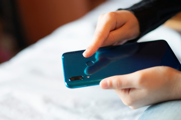Hand unlocking the mobile with fingerprint.