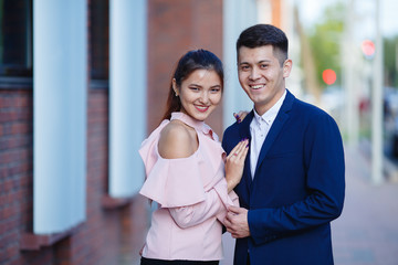 An Asian girl and her boyfriend are looking at the camera and smiling. Beautiful photo