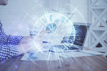 Multi exposure of businessman working on laptop on background. International business hologram in front. Concept of success.