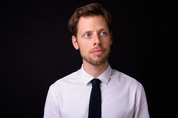 Face of handsome bearded businessman thinking and looking away