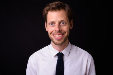 Face of happy handsome bearded businessman smiling