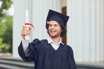 A young man graduate is smiling on university graduates.