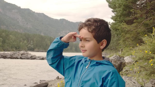 Portrait Of Boy Looking At The River In Mountains In Summer