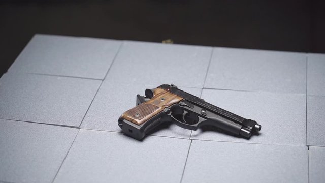 Slow Motion of Empty Bullet Casings Falling on Handgun