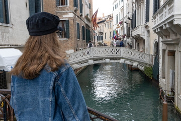 Fototapeta na wymiar girl standing on a bridge in venice italy