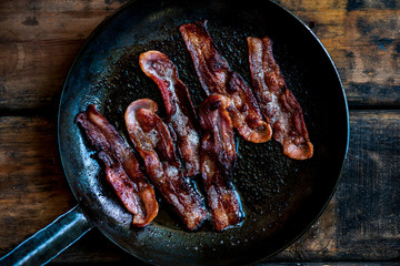Streaky bacon fried in black cast iron pan
