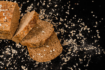 Close-up shot of a whole grain bread and slices on dark background