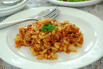 fried macaroni with egg, pork and vegetable in tomato sauce in plate