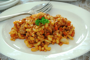 fried macaroni with egg, pork and vegetable in tomato sauce in plate