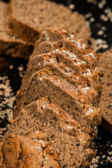 Close-up shot of a whole grain bread and slices on dark background