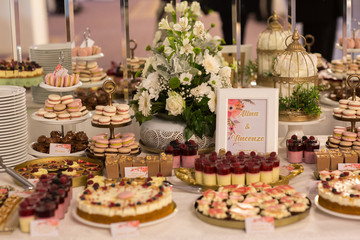 Delicious candy bar with macaroons, cupcakes and other sweets