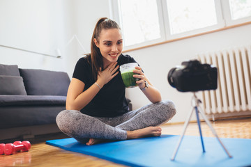 young woman making video blog from her home about healthy living and exercises