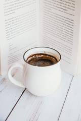 background. cup of latte or cappuccino coffee with a book in coffee shop with vintage retro filter effect