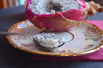 Dragon fruit or pitaya fruit Hylocereus undatus. Sectional view on a wooden background. Tropical, exotic pitaya fruit.