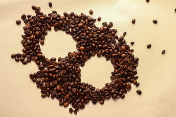 Coffee grains with space for text on brown paper background