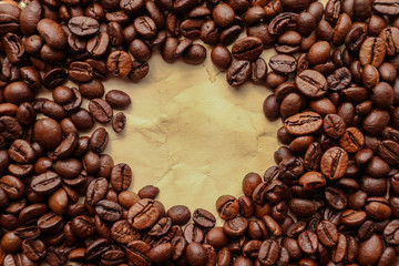 Coffee grains with space for text on brown paper background