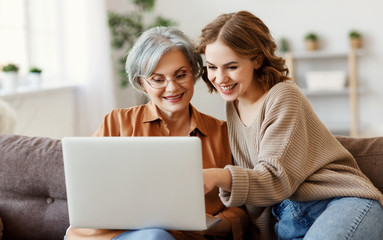 Young woman with mother using laptop at home