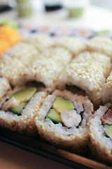 Sushi roll in sesame seeds with tiger prawns