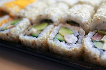 Sushi roll in sesame seeds with tiger prawns