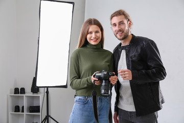 Professional photographer showing pictures to model in studio