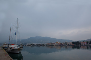 Fototapeta na wymiar winter landscape with fog and boats of port city in greece