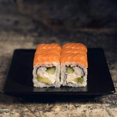 Sushi with salmon and shrimp on a black plate