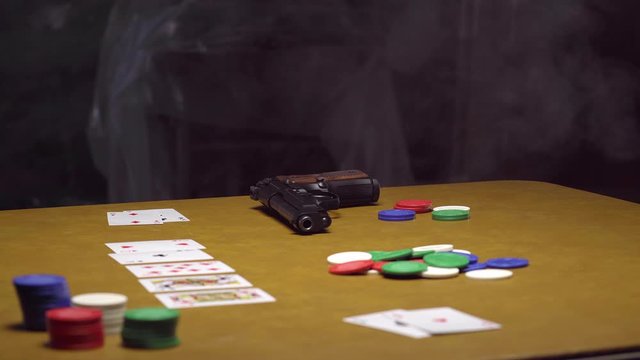 Handgun Rests on Abandoned Poker Table in Smokey Room