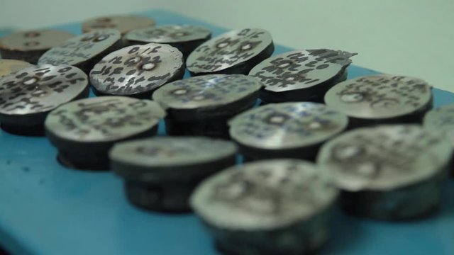 Metal ingot samples for quality control checks through a spectrograph at a foundry. Samples are numbered and coded as part of the ISO process at the foundry