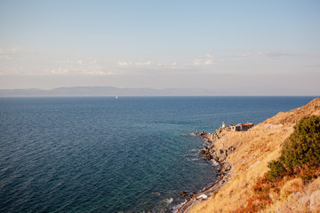 maritime landscape with cape and lighthouse at sunset