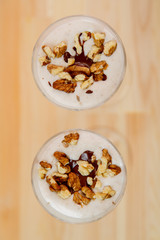 Top view of ice cream smoothie with banana and nuts sprinkled with chocolate.