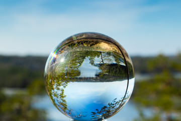 Beautiful landscape in glass ball with icy lake in the national park Repovesi, Finland