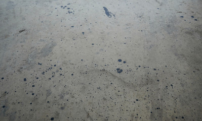 Grey cement wall, floor with random dark splashes on surface.  Renovation, decoration ideas for background and building objects.