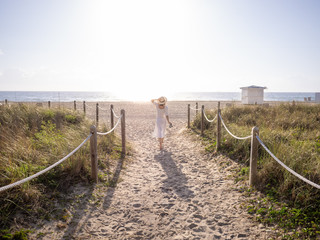 Fototapeta na wymiar Walking girl on the beach