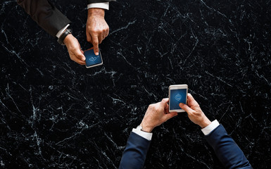 Business people syncing data by mobile phone
