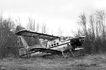 Old destroyed Soviet abandoned military airplanes in the field in Ukraine, black and white