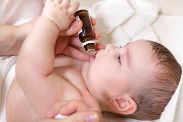 A doctor gives newborn baby vitamin D3. Child immunization with drop in clinic