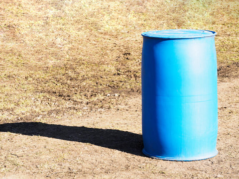 One blue plastic barrels stand on ground. The concept of safe storage of liquids