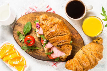 Croissant sandwich on white table.