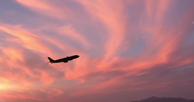 Vista laterale di un aereo passeggeri al decollo di fronte a un tramonto
