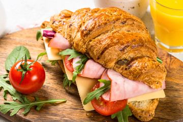 Croissant sandwich on white table.