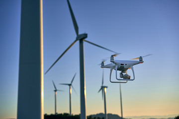 Drone flying over a background of wind turbines