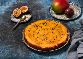 Delicious whole mango upside down cake with passion fruit on a dark rustic background. Homemade food concept. Selective focus. Copy space.