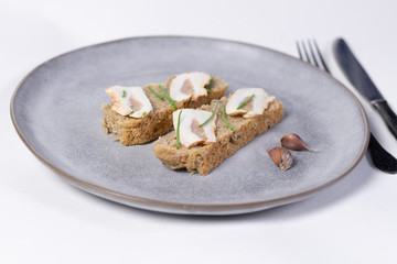 Open sandwich with homemade fat,  bread, scallions, garlic on gray plate on white background