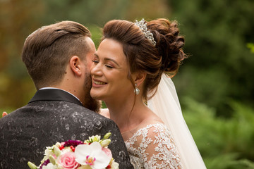 Beautiful wedding couple posing outdoor in park