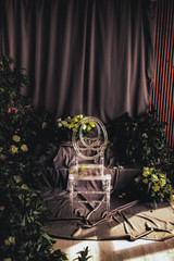 transparent chair in a wedding decor, lit by lateral sunlight, around flowers and rose leaves
