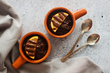 Delicious chocolate pudding with orange. Potted pudding on the table