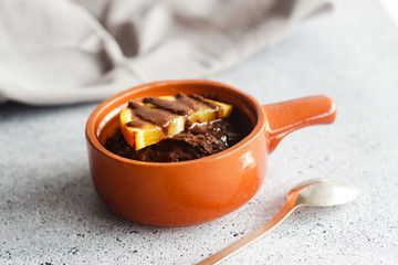 Delicious chocolate pudding with orange. Potted pudding on the table