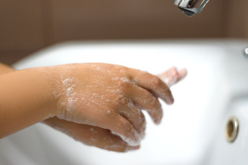 Fototapeta premium Washing of hands with soap under the crane with water.