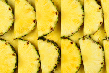 Pineapple juicy yellow slices background. Top view.