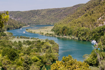 Obraz premium SIBENIK, CROATIA - 2017 AUGUST 18. Krka National Park. Beautiful nature and landscape photo. Nice warm summer day. Lovely outdoors image with mountains and boats on river